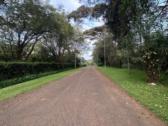Rich1 Acre Land for Sale in Karen in a gated community, with a driveway and red soil. Asking Price: 70M. Musilli Homes.